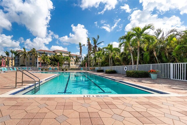 community pool with fence and a patio