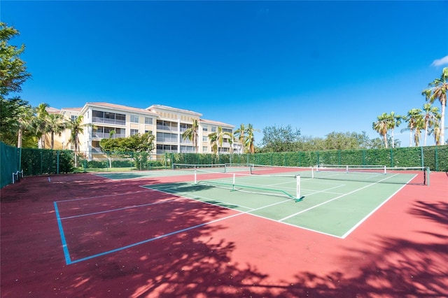 view of tennis court with community basketball court and fence