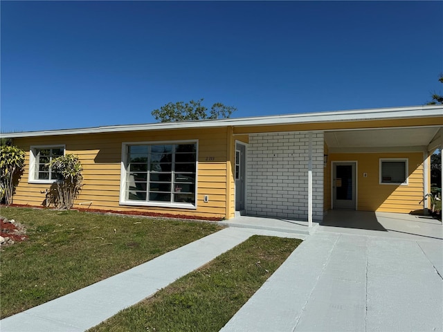 view of front of property featuring a front yard and a carport