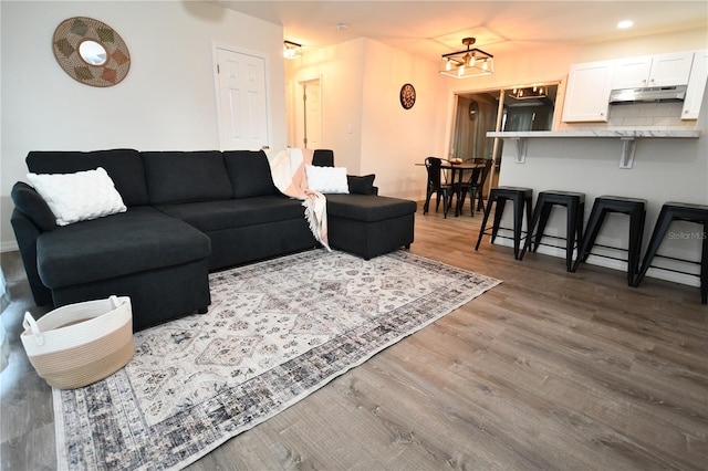 living room featuring wood-type flooring and a notable chandelier