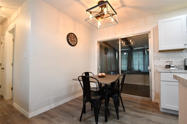 dining area featuring dark hardwood / wood-style floors and an inviting chandelier