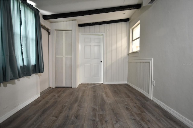 unfurnished bedroom with dark wood-type flooring and lofted ceiling with beams