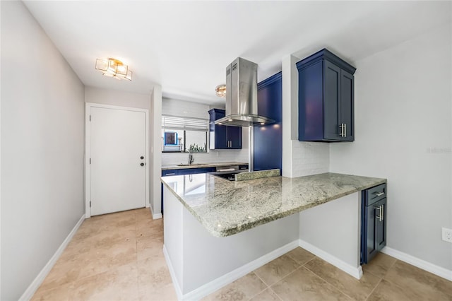1001 W Marion Ave Unit 14, Punta Gorda, FL 33950 - kitchen featuring a peninsula, blue cabinetry, island exhaust hood, a sink, and decorative backsplash