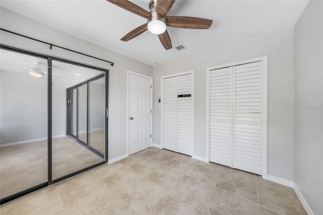 1001 W Marion Ave Unit 14, Punta Gorda, FL 33950 - unfurnished bedroom with visible vents, baseboards, two closets, and a ceiling fan