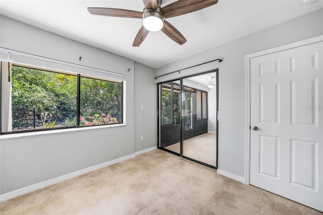 1001 W Marion Ave Unit 14, Punta Gorda, FL 33950 - unfurnished bedroom with light tile patterned floors, access to exterior, baseboards, and ceiling fan