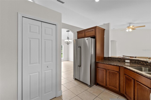 kitchen featuring ceiling fan with notable chandelier, decorative light fixtures, high end refrigerator, sink, and light tile patterned flooring