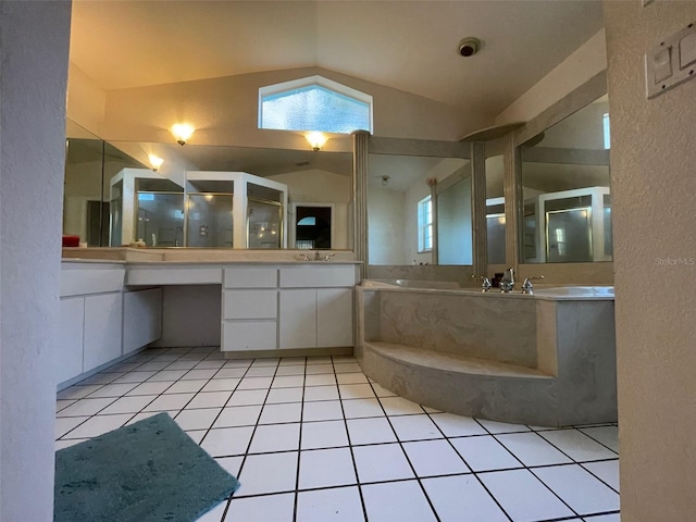 bathroom featuring tile patterned floors, a tub to relax in, vanity, and vaulted ceiling