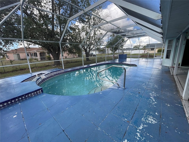 view of pool with glass enclosure and a patio area