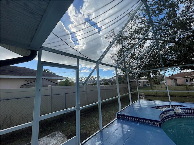 view of swimming pool featuring glass enclosure and a jacuzzi