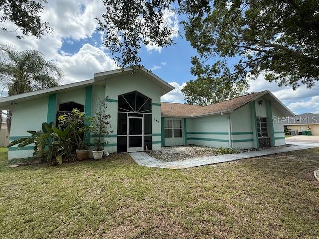 269 Rosemary St, Port Charlotte, FL 33954 - back of house featuring a lawn and stucco siding