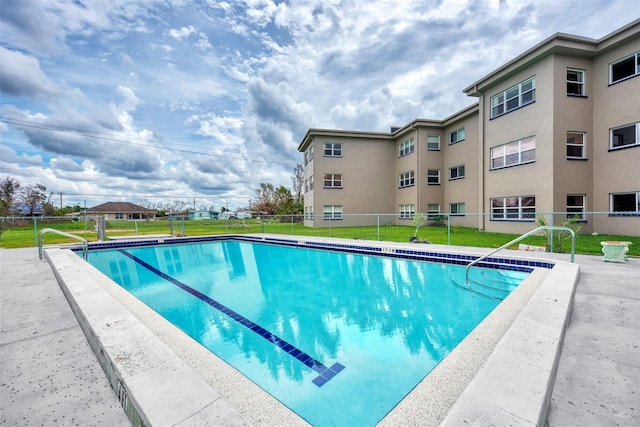 view of pool featuring a lawn