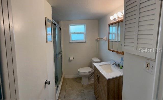 bathroom featuring vanity, toilet, a shower with door, and tile patterned flooring