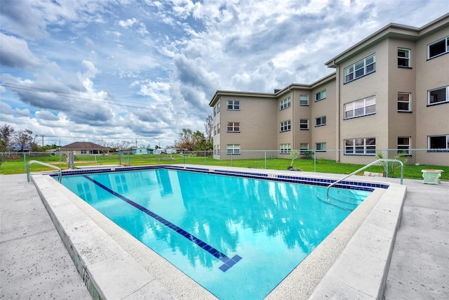 community pool featuring fence and a yard