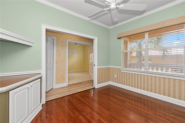 spare room featuring ceiling fan, hardwood / wood-style flooring, wooden walls, and ornamental molding