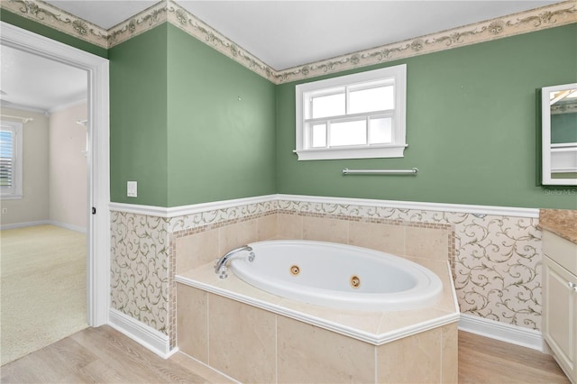 bathroom featuring vanity, a relaxing tiled tub, and hardwood / wood-style floors