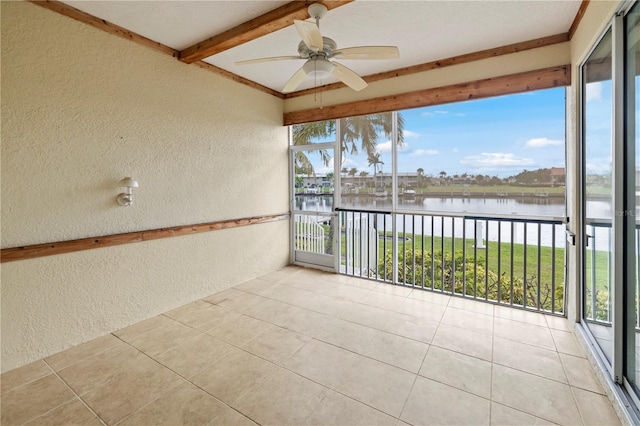 unfurnished sunroom with a water view, ceiling fan, and beamed ceiling