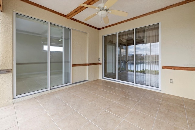 tiled spare room featuring ornamental molding and ceiling fan