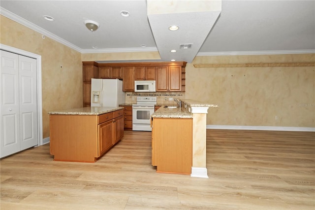 kitchen with white appliances, light stone counters, light hardwood / wood-style floors, and crown molding