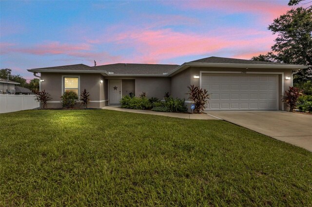 view of front of house featuring a garage and a lawn