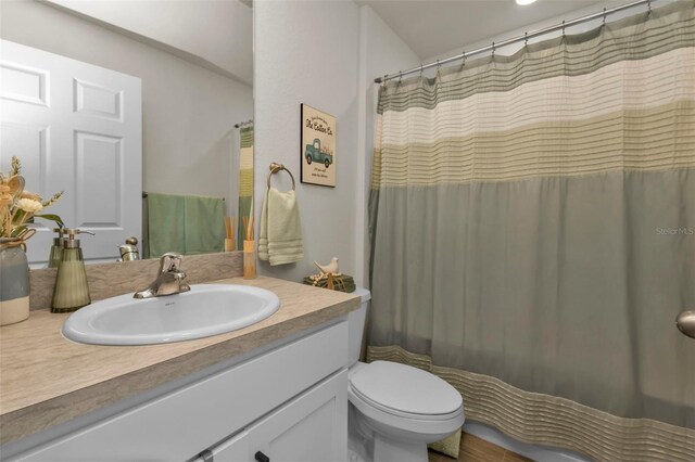 bathroom featuring vanity, toilet, and curtained shower