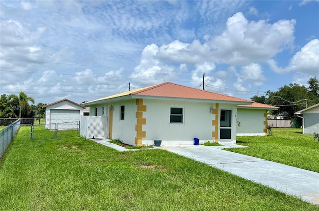 rear view of house featuring an outdoor structure, a garage, and a yard