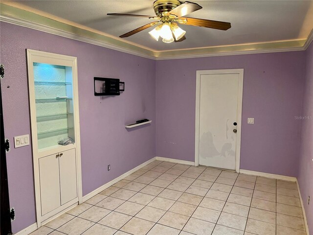 tiled spare room with ceiling fan and crown molding