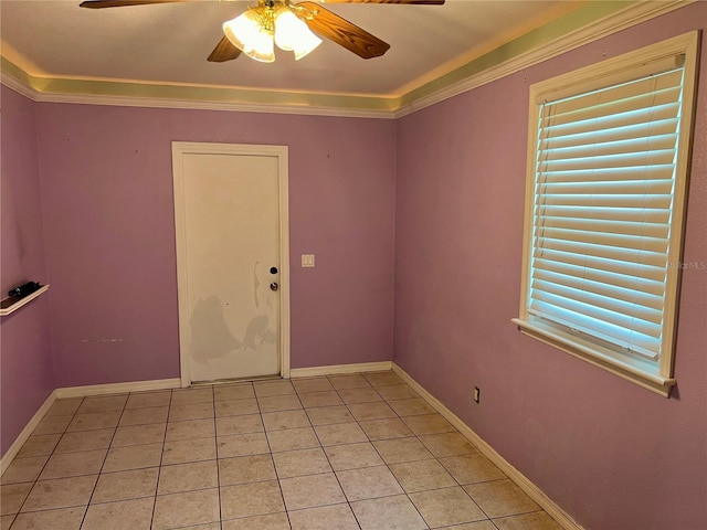 tiled empty room featuring ceiling fan and ornamental molding