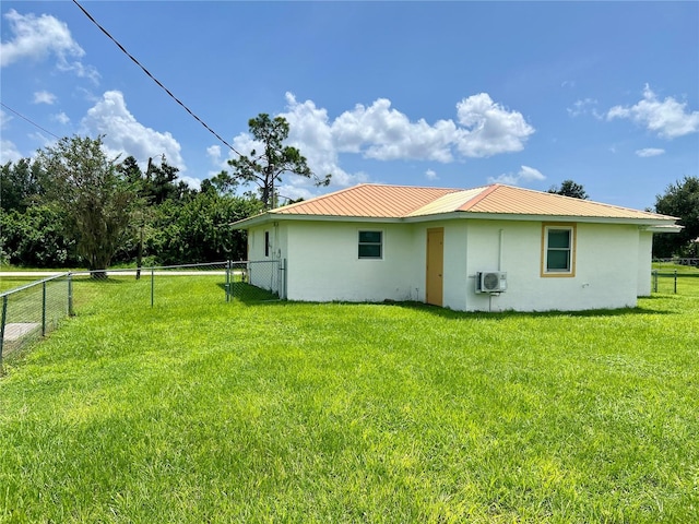 rear view of house featuring a yard and a wall mounted air conditioner