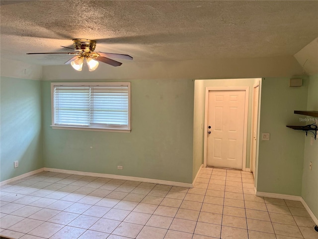 tiled empty room with a textured ceiling and ceiling fan