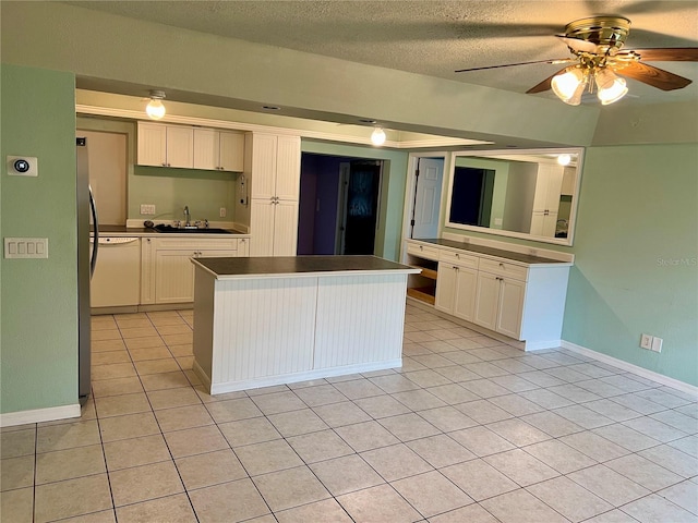 kitchen with ceiling fan, a center island, white cabinetry, and a textured ceiling