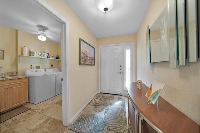 entrance foyer with washer and dryer, ceiling fan, and sink