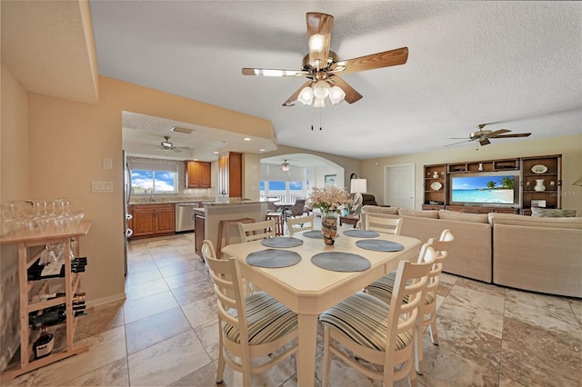 tiled dining room featuring ceiling fan and a textured ceiling