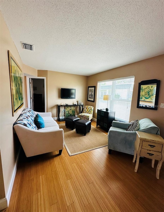 living room featuring hardwood / wood-style flooring and a textured ceiling