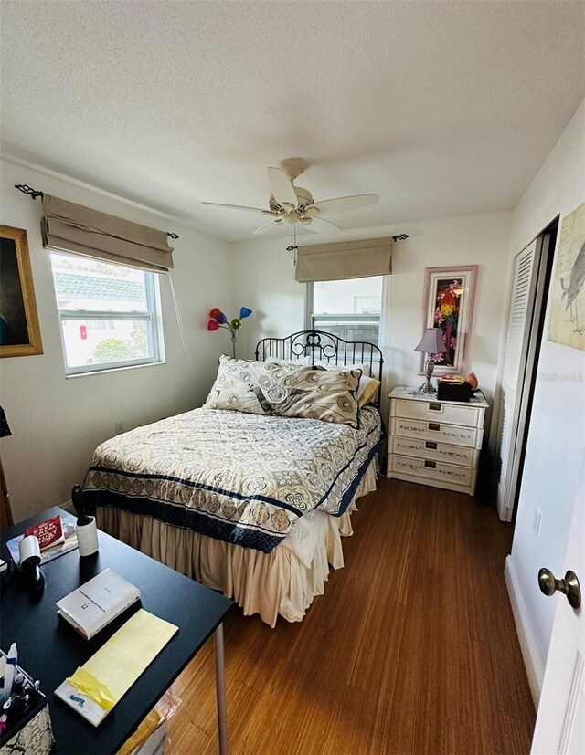 bedroom featuring a textured ceiling, ceiling fan, a closet, and dark hardwood / wood-style flooring