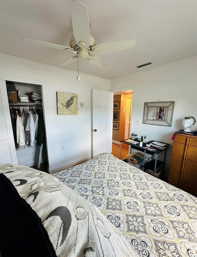 bedroom with hardwood / wood-style floors, ceiling fan, and a closet