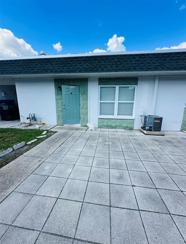 doorway to property featuring a patio and central AC