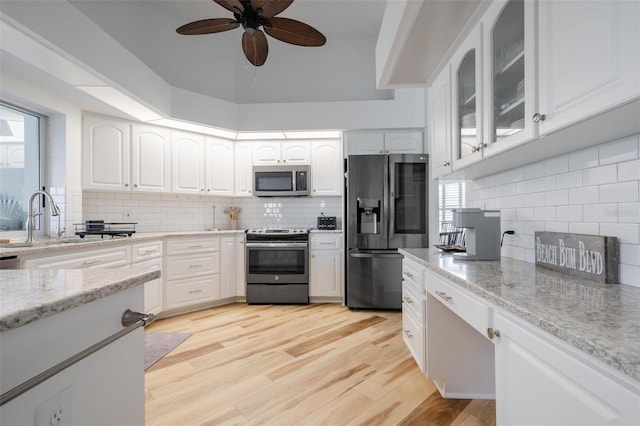 kitchen with white cabinetry, a wealth of natural light, ceiling fan, appliances with stainless steel finishes, and light hardwood / wood-style floors