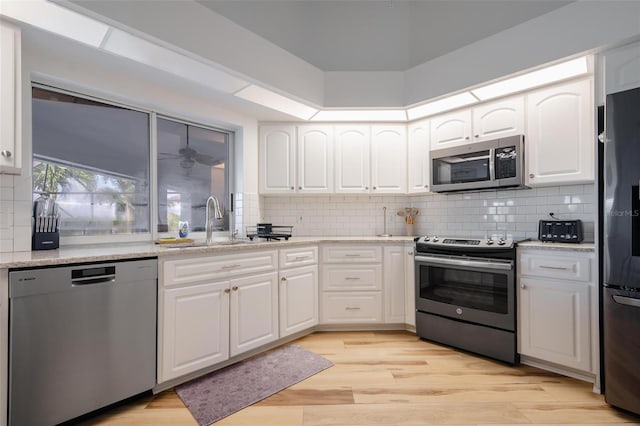 kitchen featuring white cabinetry, stainless steel appliances, sink, and light hardwood / wood-style floors