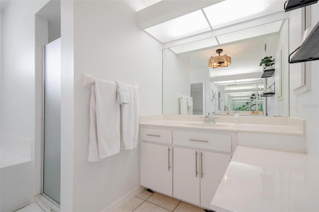 bathroom featuring tile patterned floors, a shower with door, and vanity