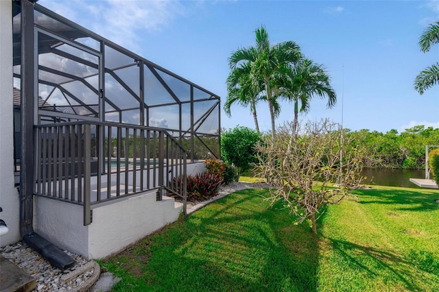 view of yard with a lanai and a water view