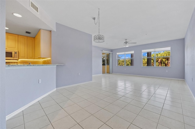 unfurnished living room with ceiling fan and light tile patterned floors