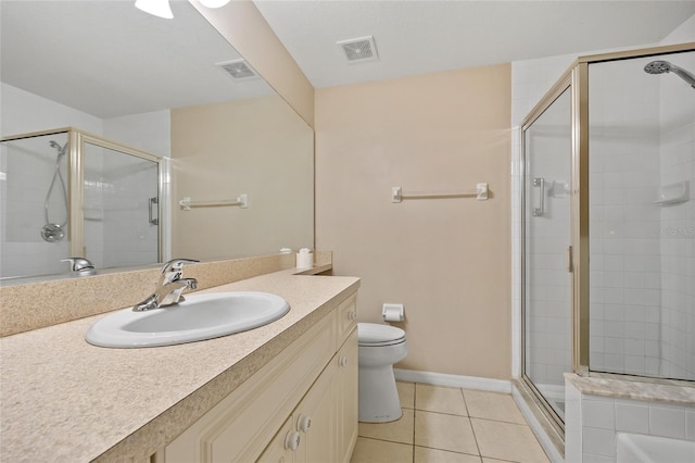 bathroom featuring vanity, toilet, a shower with shower door, and tile patterned flooring