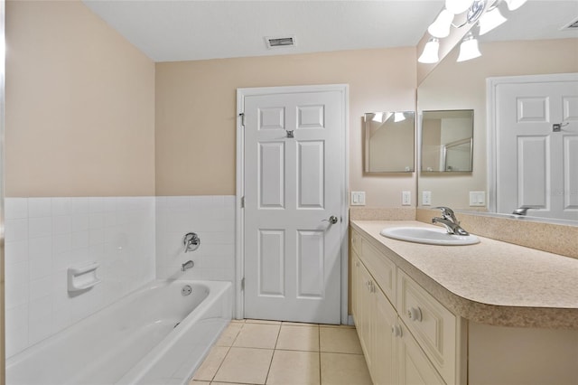 bathroom with a tub, tile patterned flooring, and vanity