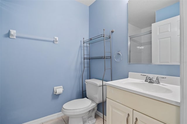 bathroom with a shower with door, vanity, toilet, and tile patterned floors