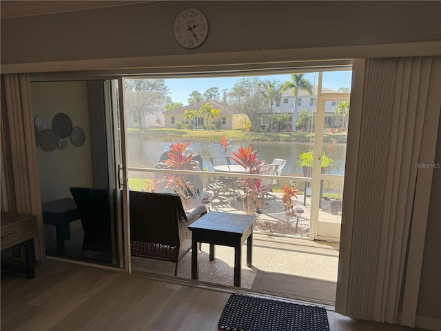 doorway with a water view and hardwood / wood-style floors