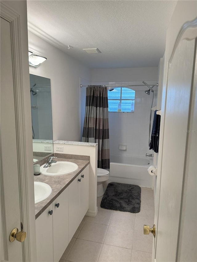 full bathroom featuring toilet, vanity, tile patterned flooring, shower / tub combo, and a textured ceiling