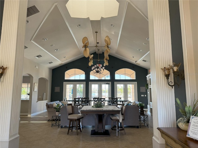 dining room with an inviting chandelier, tile patterned floors, a wealth of natural light, and a high ceiling