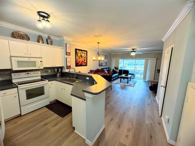 kitchen with kitchen peninsula, white appliances, crown molding, white cabinets, and sink