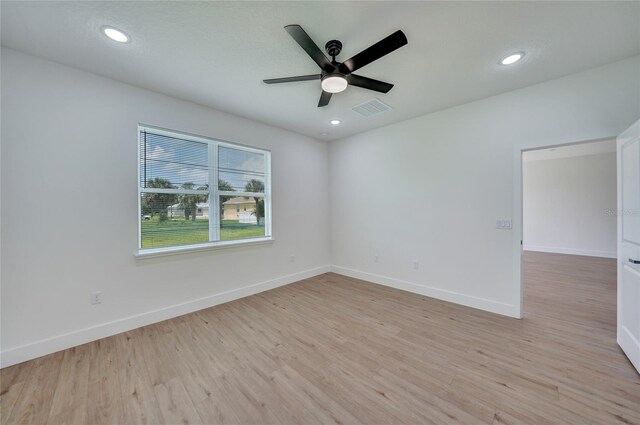 spare room with ceiling fan and light wood-type flooring