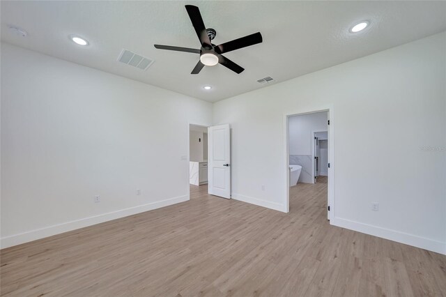 unfurnished bedroom with light wood-type flooring, ensuite bathroom, and ceiling fan